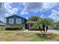 Charming two-story home featuring blue siding, white shutters, and well-maintained landscaping at 1902 Rebecca Rd, Lutz, FL 33548