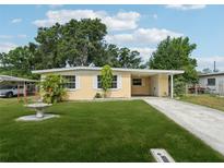 Charming single-story home featuring a well-manicured lawn and a welcoming carport at 2044 Temple Ter, Clearwater, FL 33764
