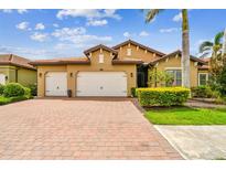 Charming home featuring a brick driveway, manicured landscaping, and a spacious three-car garage at 222 Toscavilla Blvd, Nokomis, FL 34275
