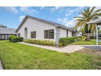 Charming single-story home featuring manicured landscaping and a mature palm tree at 2749 Countryside Blvd # 20, Clearwater, FL 33761