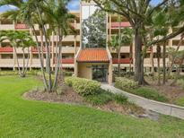 Inviting building entrance with lush landscaping and tall palm trees, offering a serene welcome at 3062 Eastland Blvd # 405, Clearwater, FL 33761