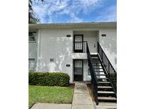 Condominium exterior showing the front entrances with a staircase and well-maintained landscaping at 3802 N Oak Dr # W22, Tampa, FL 33611