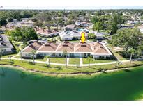 An aerial view of a waterfront townhome featuring a lush green lawn and scenic water views at 4324 Tahitian Gardens Cir # J, Holiday, FL 34691