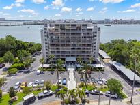 An aerial view shows the building, parking and waterfront location on a sunny day at 500 N Osceola Ave # 811, Clearwater, FL 33755
