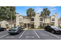 Townhouse exterior featuring neutral paint, a well manicured landscape, and ample parking with mature palm trees at 5100 Burchette Rd # 2702, Tampa, FL 33647