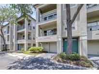 Three-story condo building featuring balconies, attached garages, and mature trees offering shade at 731 Cruise View Dr, Tampa, FL 33602