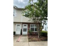 Charming two-story townhome with brick accents and a well-manicured front yard at 7616 Colonial Ct, Tampa, FL 33615