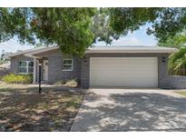 Charming single-story home featuring a two-car garage and stone facade with mature landscaping at 11110 105Th Ave, Largo, FL 33778
