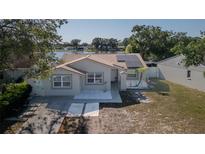 Charming single-story home with fresh exterior paint, solar panels, and a view of the serene lake at 12416 Queensland Ln, Tampa, FL 33625