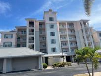 Beautiful condo with multiple floors, light pink exterior, and blue window shutters at 13313 Gasparilla Rd # 401, Placida, FL 33946