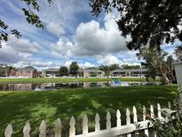 Scenic waterfront view from townhome featuring a pond, green lawn, and serene atmosphere at 13709 Juniper Blossom Dr, Tampa, FL 33618
