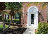 Inviting brick home with a front door framed by lush tropical landscaping and a charming arched entryway at 13755 Orange Sunset Dr # 101, Tampa, FL 33618