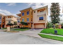Beautiful three-story home featuring multiple balconies, manicured lawn, and a two-car garage at 1531 Ember Ln, Tarpon Springs, FL 34689