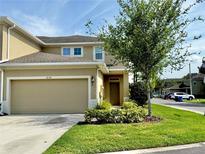 Inviting two-story home featuring a well-manicured lawn, a two-car garage, and a beautifully landscaped entrance at 2130 Broadway View Ave, Brandon, FL 33510