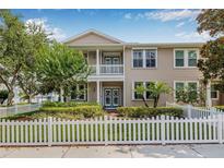 Inviting townhouse with a covered porch, balcony, and a charming white picket fence at 311 1St Sw Ave, Largo, FL 33770