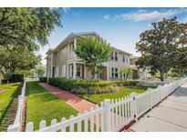 Inviting townhome boasts a well-manicured lawn and charming white picket fence, creating a cozy curb appeal at 311 1St Sw Ave, Largo, FL 33770