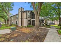 Charming condo with lush landscaping, mature trees, and visible stairway access at 4004 Dream Oak Pl # 102, Tampa, FL 33613