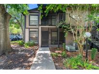 Inviting two-story condo featuring a covered porch and well-maintained landscaping at 4004 Dream Oak Pl # 102, Tampa, FL 33613