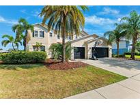 Charming two-story home features lush landscaping, a basketball hoop, and a spacious three-car garage at 5457 Sandy Shell Dr, Apollo Beach, FL 33572
