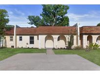 Charming townhouse featuring an arched entryway, fresh landscaping, and a spacious driveway at 9831 83Rd Way, Seminole, FL 33777