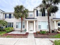 Charming townhome showcasing a beige exterior, palm trees, and a welcoming front entrance at 12268 Country White Cir, Tampa, FL 33635