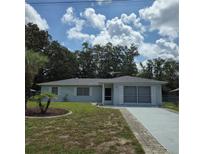 Charming single-story home with lush landscaping and a well-manicured lawn under a blue sky at 2226 Giralda Ave, Spring Hill, FL 34606