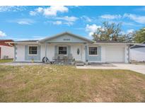 Charming single-story home with a well-maintained lawn and inviting front porch seating at 6639 Winding Oak Dr, Tampa, FL 33625