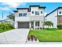 Striking modern two-story home with stone accents, sleek garage door, and freshly manicured lawn at 710 W Plymouth St, Tampa, FL 33603
