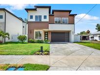 Modern two-story home featuring mixed-material facade, well-maintained lawn, and contemporary garage door for enhanced curb appeal at 712 W Plymouth St, Tampa, FL 33603