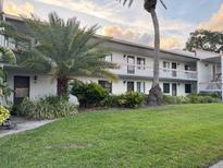 A well-maintained two-story exterior featuring balconies and mature landscaping at 105 Lakeview Way # 105, Oldsmar, FL 34677