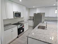 Bright kitchen features white cabinets, stainless steel appliances, granite countertops, and an island with a sink at 11210 Mcmullen Rd, Riverview, FL 33569