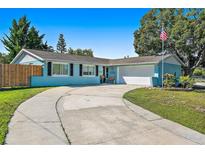 Charming single-story home featuring a well-manicured lawn, blue exterior, and a spacious driveway at 11296 90Th Ave, Seminole, FL 33772
