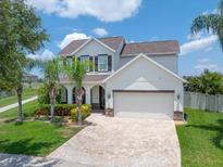 Charming two-story home featuring a brick driveway, lush landscaping, and a welcoming front porch at 11904 Greenchop Pl, Riverview, FL 33579