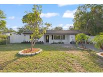 Charming one-story home with a well-manicured lawn, small trees, and updated exterior at 15025 Shark St, Hudson, FL 34667