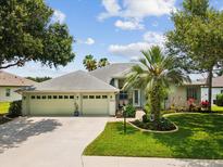 Charming single-story home with a well-manicured lawn, palm trees, and a three-car garage at 2730 River Woods Dr, Parrish, FL 34219