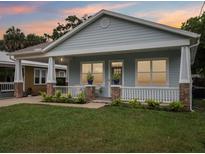 Charming single-story home featuring a inviting front porch and a well-manicured lawn at 311 W Ida St, Tampa, FL 33603