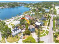 Aerial view of a blue, two-story home with a waterfront view, lush landscaping, and a convenient location at 4100 Miramar Way, St Petersburg, FL 33705