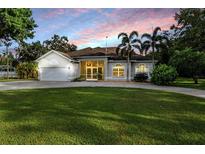 Beautiful single-story home with a well-manicured lawn, lush landscaping, and a two-car garage at 6411 Barton Rd, Plant City, FL 33565