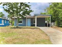 Cozy single-story home featuring a covered carport and a cheerful blue front door at 7307 34Th N Ave, St Petersburg, FL 33710