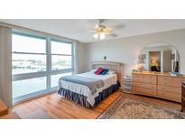 Bright bedroom features a large window with water views, hardwood floors, and a ceiling fan at 7600 Sun Island S Dr # 407, South Pasadena, FL 33707