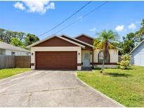 Charming single-story home with a well-maintained lawn, brown accents, and attached two-car garage at 7712 40Th N Ter, St Petersburg, FL 33709