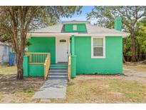 Charming green home featuring a welcoming porch and newly landscaped front yard at 8215 N 14Th St, Tampa, FL 33604