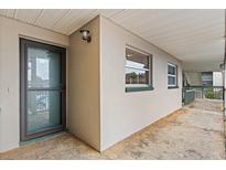 A ground-level exterior view of a condo entrance with windows and a covered walkway at 1028 Apollo Beach Blvd # 203, Apollo Beach, FL 33572