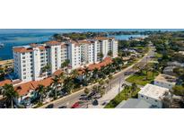 Upscale waterfront condominium building featuring a white facade, tile roof, and lush landscaping at 1325 Snell Isle Ne Blvd # 708, St Petersburg, FL 33704
