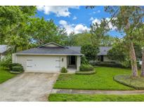 Inviting single-story home featuring a manicured front lawn and attached two-car garage at 13898 Egret Ln, Clearwater, FL 33762