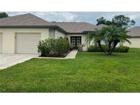 Charming home featuring a well-maintained lawn, lovely landscaping, and an attached two-car garage at 18804 Tournament Trl, Tampa, FL 33647