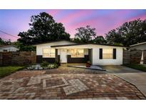 Charming home featuring neutral paint, decorative rock, shutters, and paver driveway at 2112 Ranchita Trl, Holiday, FL 34690
