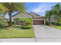 Charming single-story home with a well-manicured lawn, mature landscaping, and a two-car garage at 32193 Watoga Loop, Wesley Chapel, FL 33543