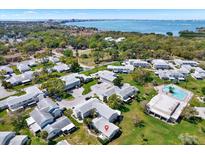 Stunning aerial view of a condo community with a pool, trees, and a view of a large body of water in the background at 3268 39Th S St # A, St Petersburg, FL 33711