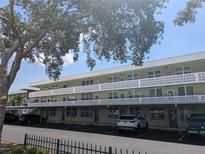 A quaint condominium building features covered parking, classic white patterned railings and neutral tones at 4705 Ne 1St Ne St # 327, St Petersburg, FL 33703